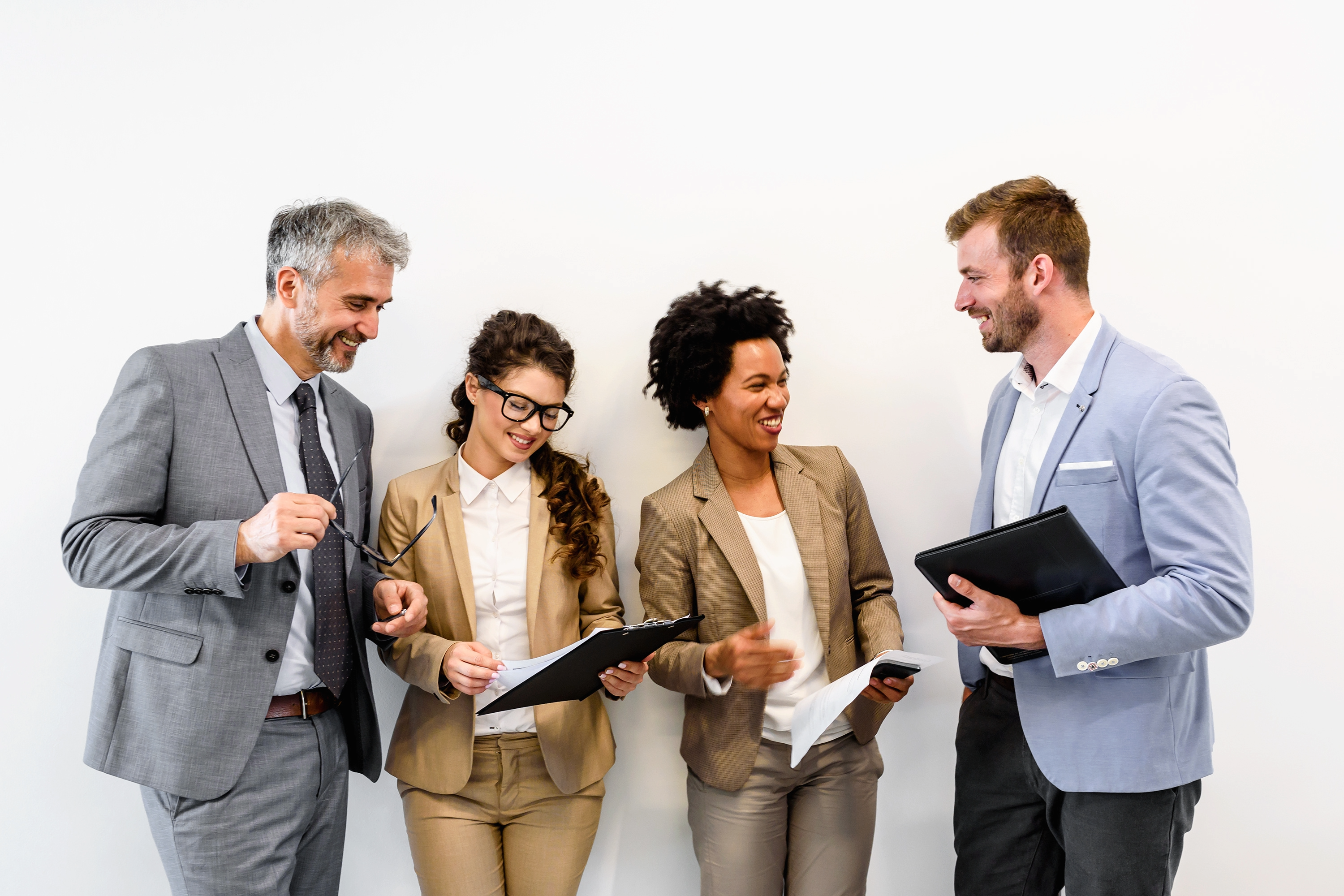 Four professionals reviewing documents and discussing talent strategy together