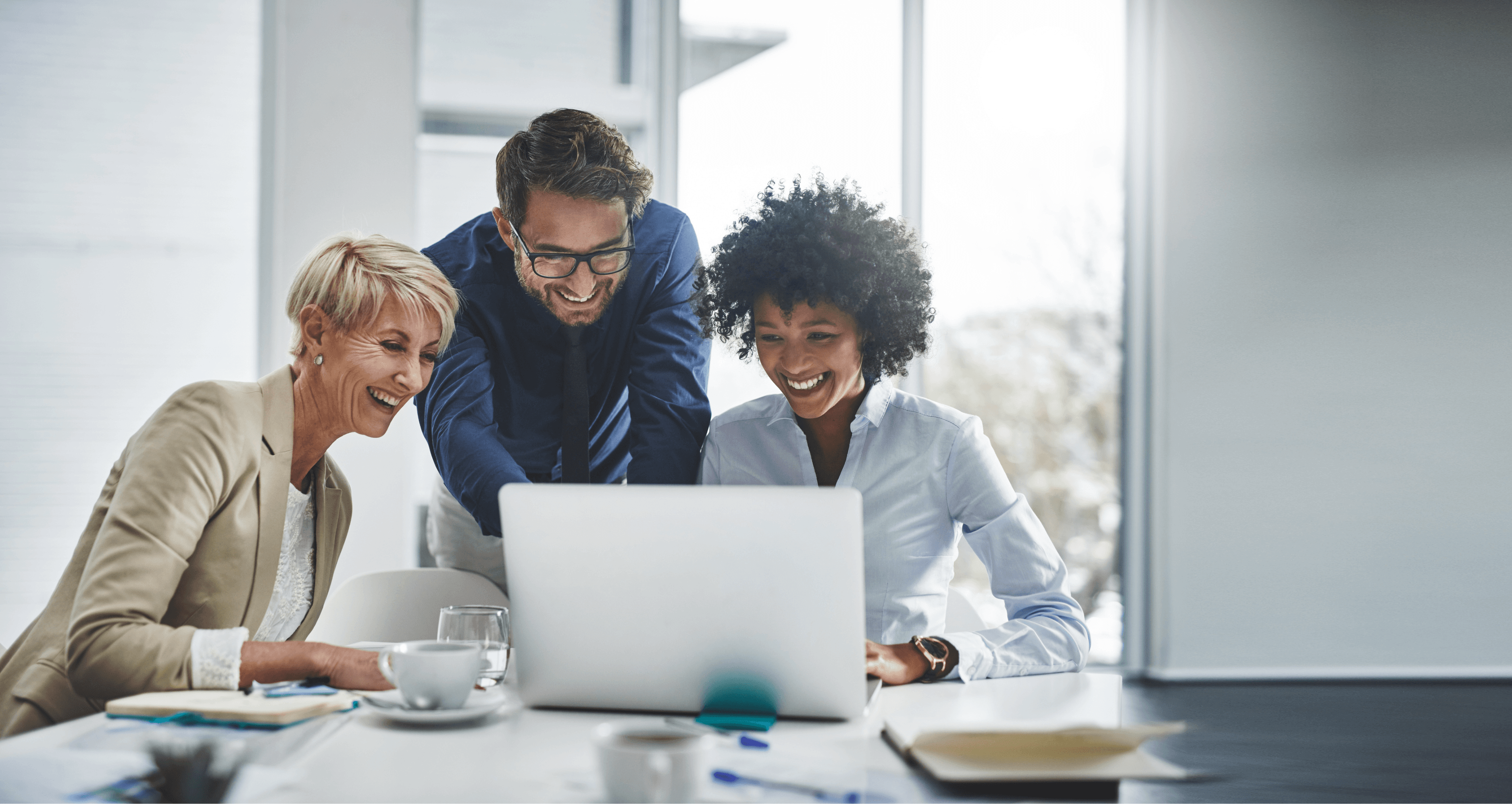 Advisors collaborating around a laptop during a strategy meeting